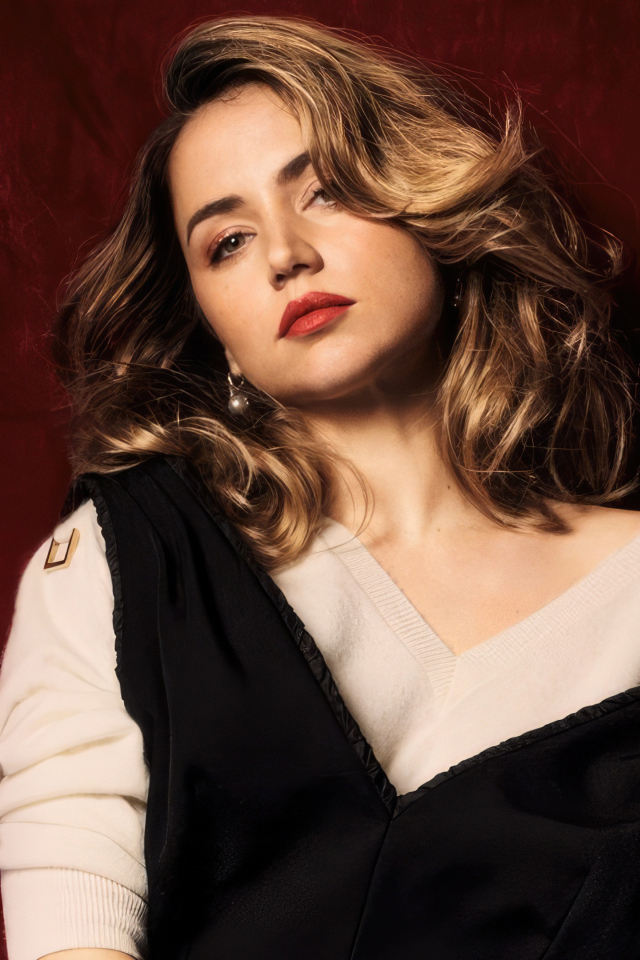 Милая актриса Ана де Армас стоит у красной стены