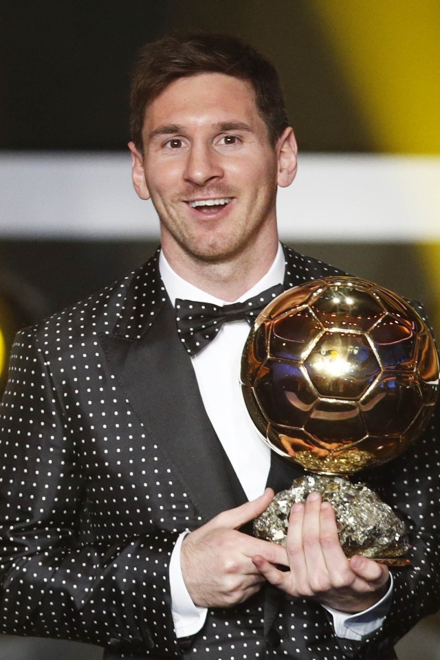Футболист Лионель Месси с золотым мячом в руках