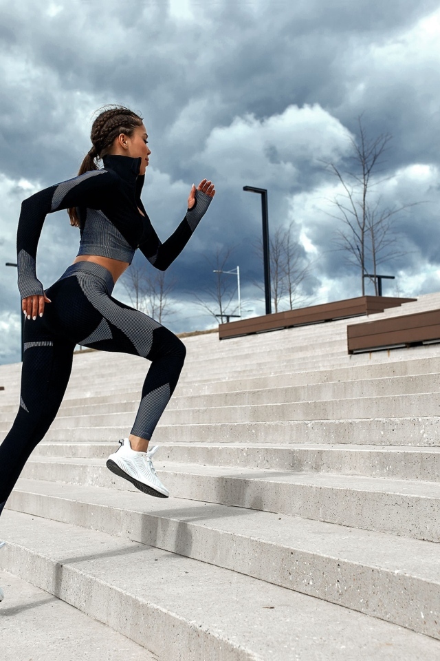 Девушка спортсменка бежит по лестнице