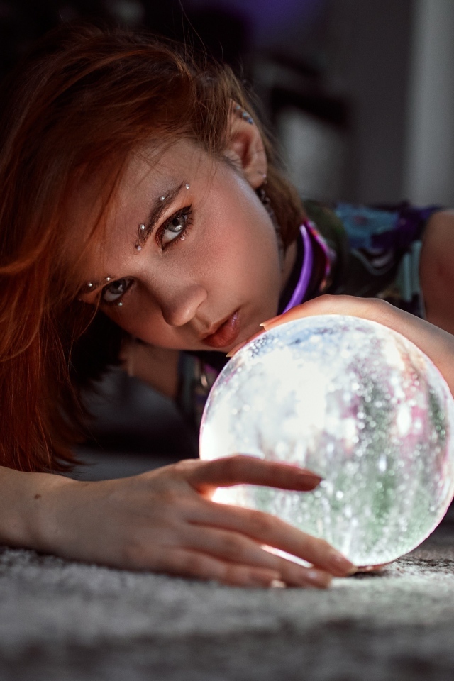 Девушка с пирсингом держит волшебный шар