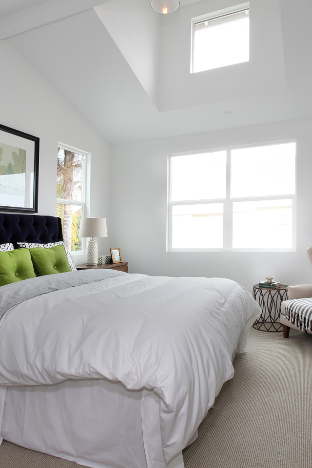 Высокая мягкая кровать в спальной комнате