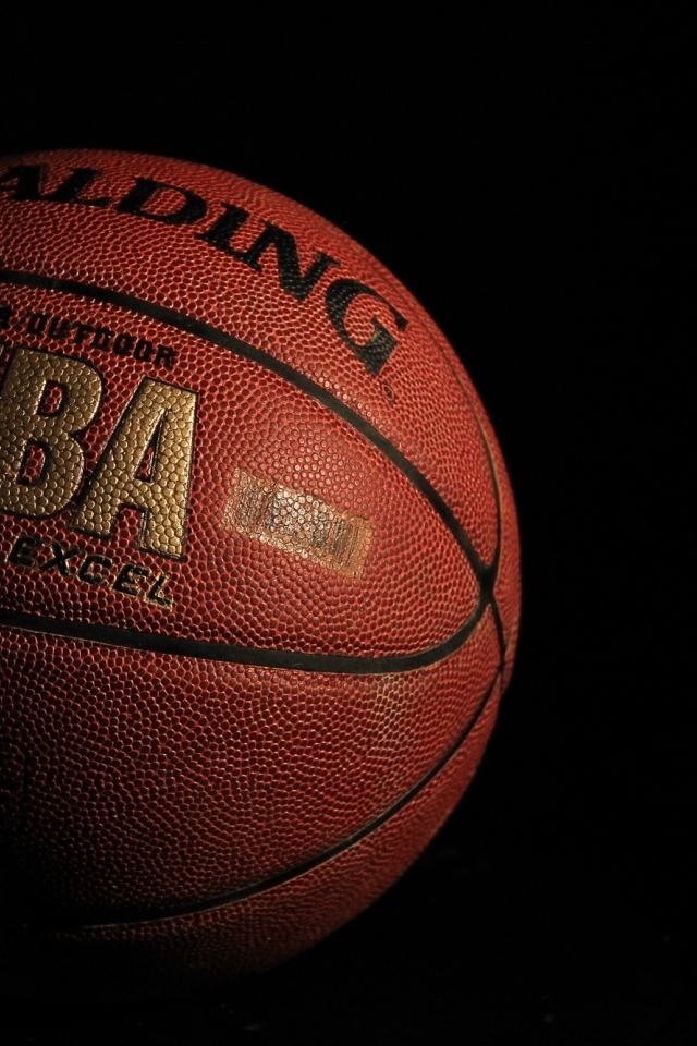 Кожаный баскетбольный мяч на черном фоне