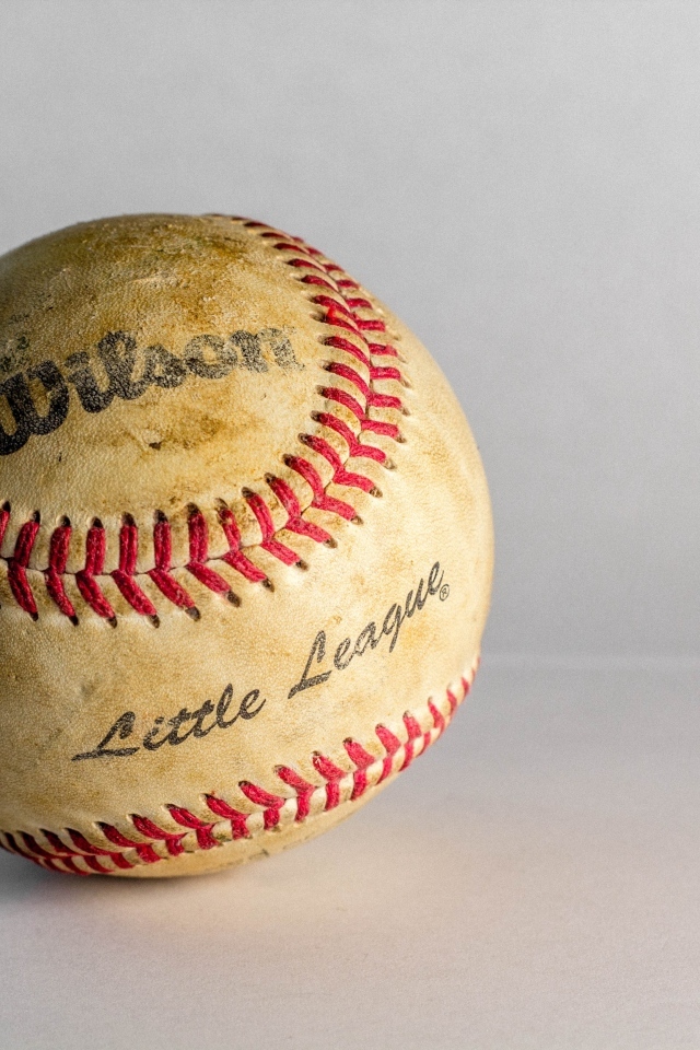 Старый бейсбольный мяч на сером фоне