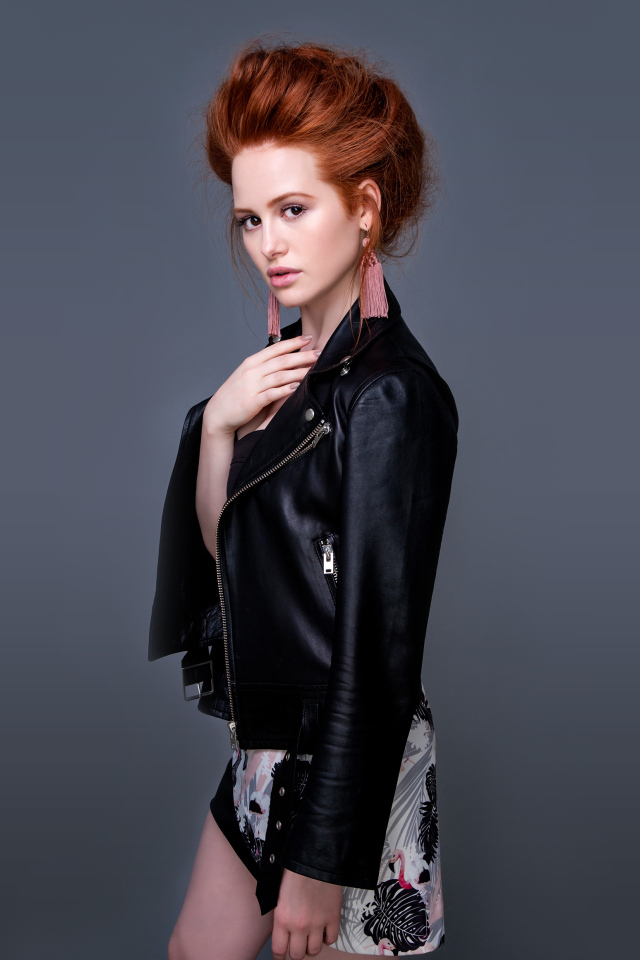 Рыжеволосая актриса Мэделин Петш в черной куртке на сером фоне