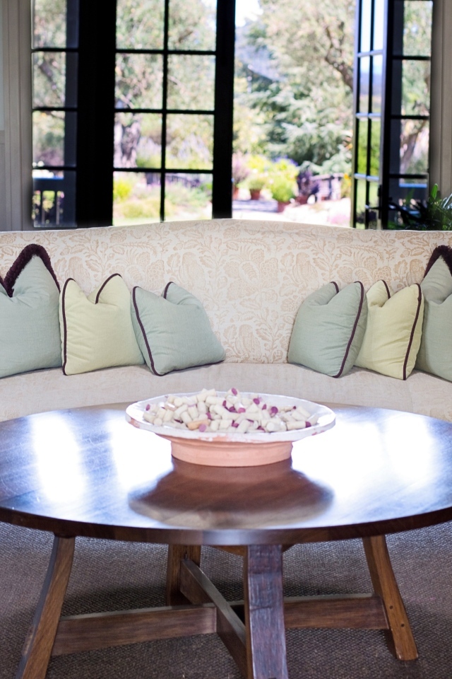 Круглый деревянный стол в гостиной с диваном