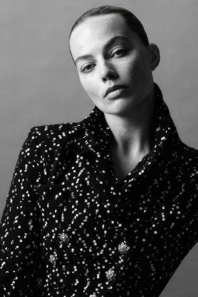 Грустная Марго Робби в блестящем пиджаке на сером фоне