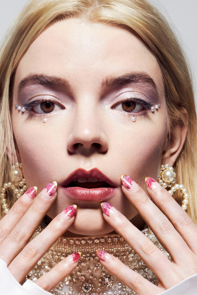 Молодая актриса Аня Тейлор-Джой с украшениями на сером фоне