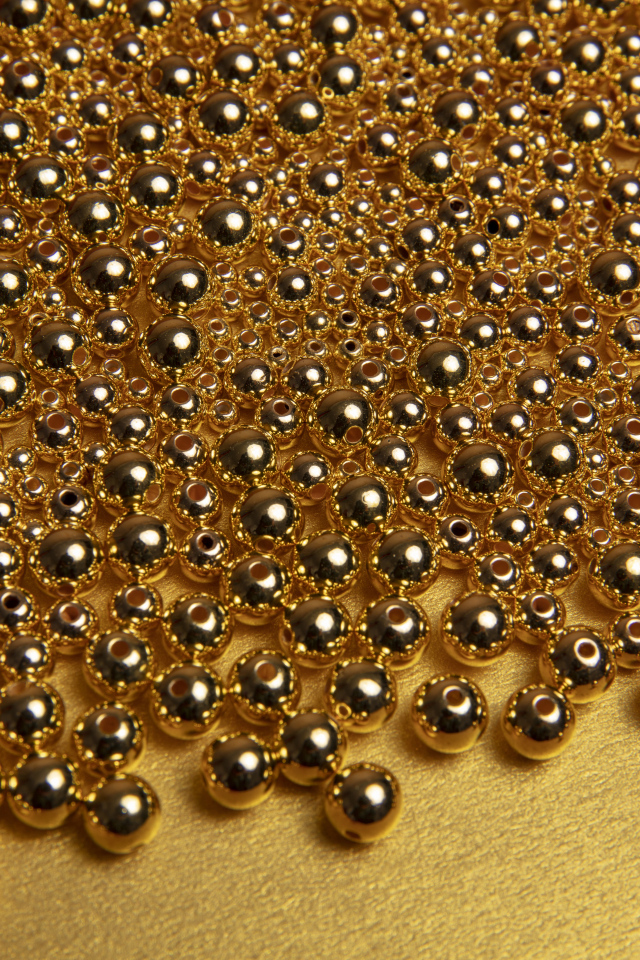 Много золотых бусин на желтом фоне