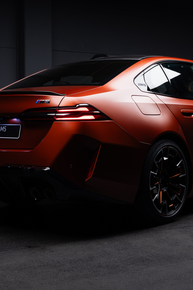 Вид сзади на красный автомобиль BMW M5 2025 года