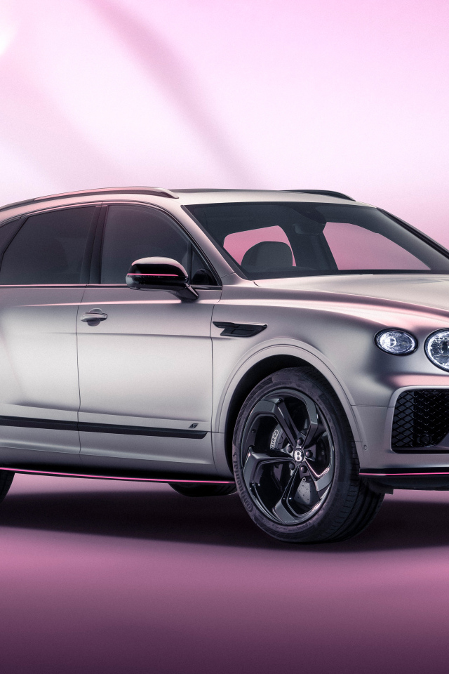 Серебристый автомобиль Bentley Bentayga V8 S Curated By Mulliner 2024 года на розовом фоне