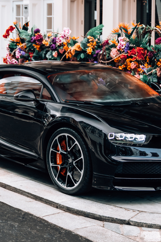 Черный автомобиль Bugatti Chiron у здания