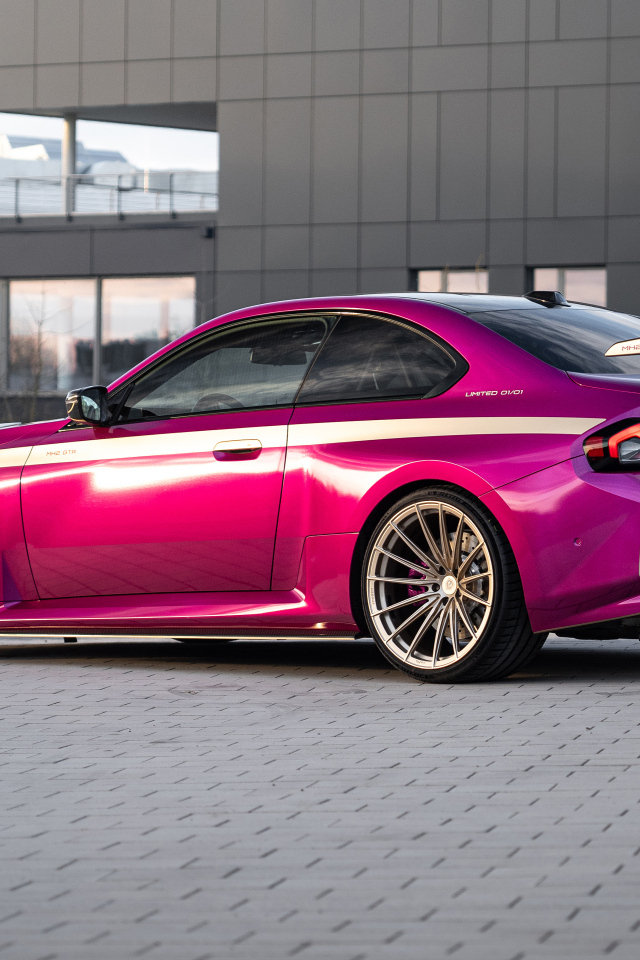 Вид сзади на розовый автомобиль Manhart MH2 GTR II 2024 года