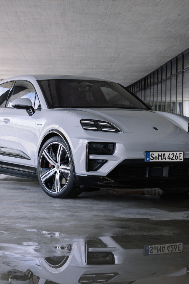 Большой Porsche Macan Turbo 2024 года у здания