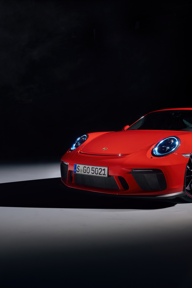 Красный автомобиль Porsche 911 GT3 на черном фоне