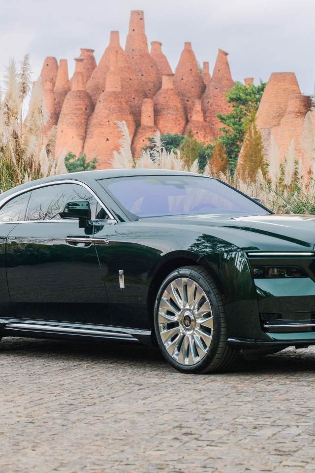 Дорогой зеленый автомобиль Rolls-Royce Spectre