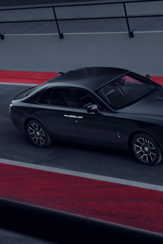 Черный автомобиль Rolls-Royce Black Badge Ghost на дороге