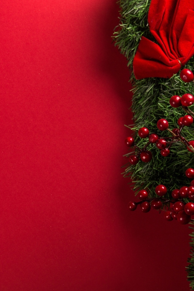 Красный фон с еловой веткой с ягодами