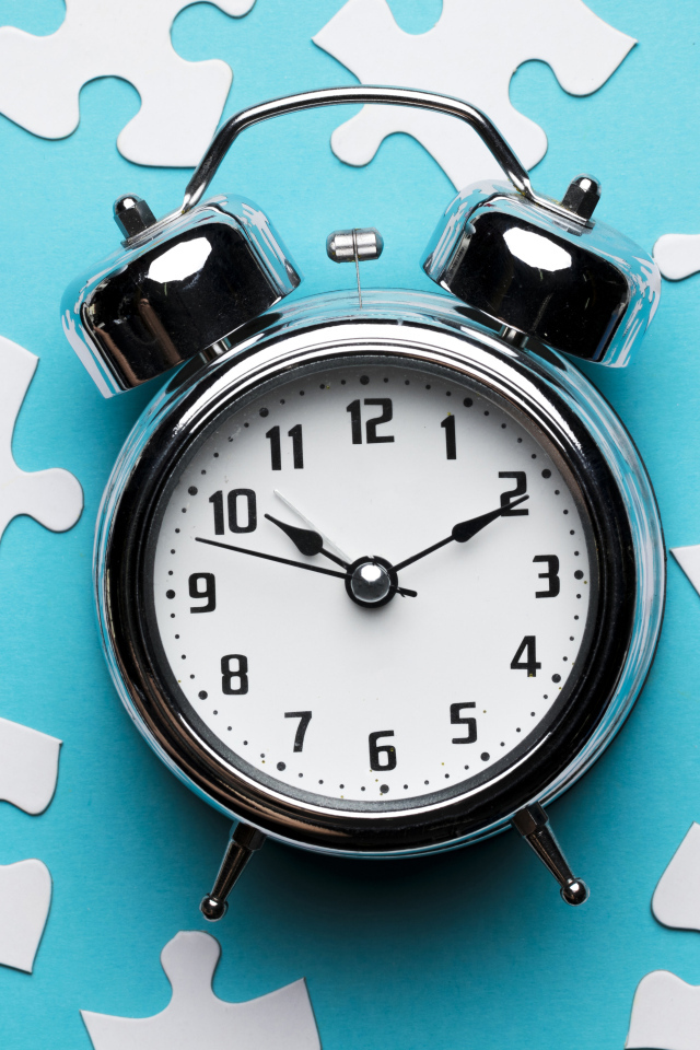 Будильник на голубом фоне с пазлами