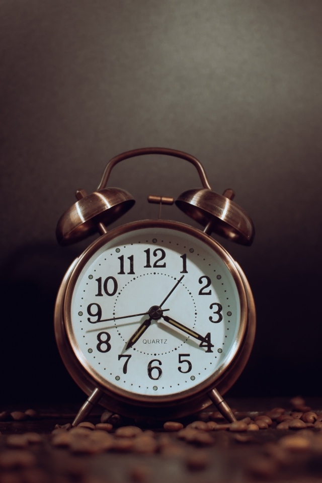 Будильник на столе с зернами кофе