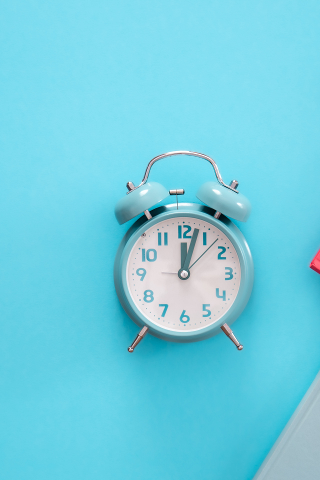 Будильник с книгами на голубом фоне