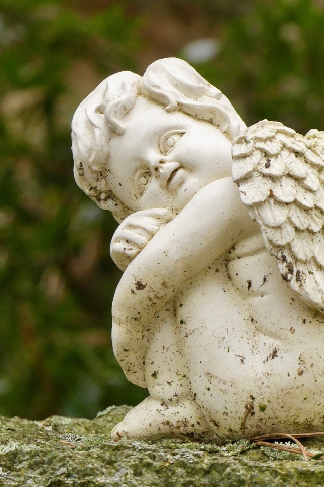 Статуэтка ангела стоит на камне