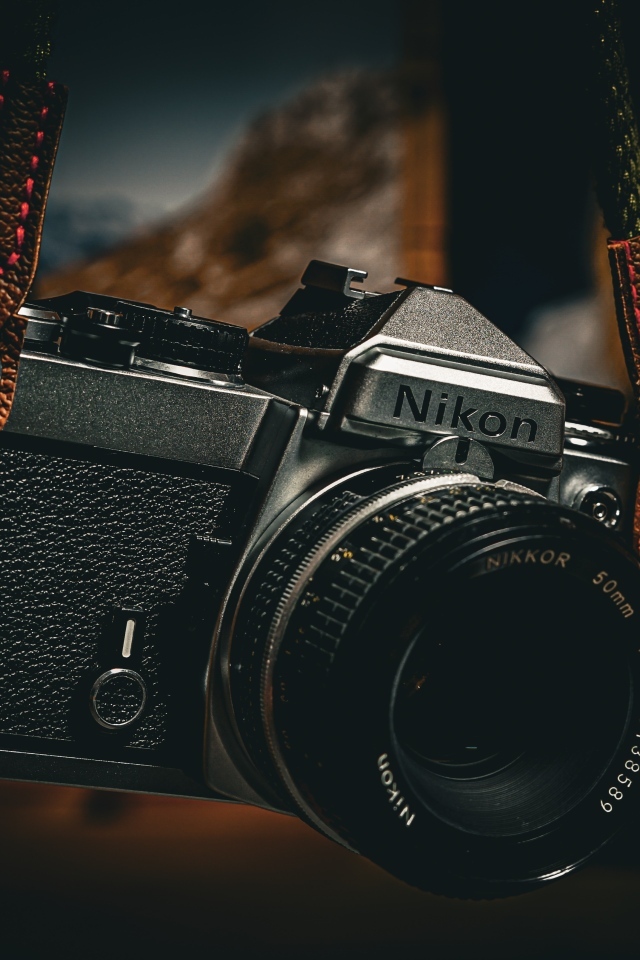 Черный фотоаппарат nikon на ремне