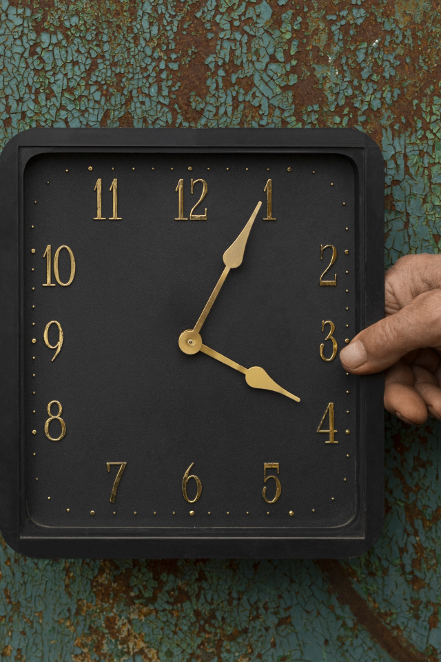 Черные квадратные часы на старой стене
