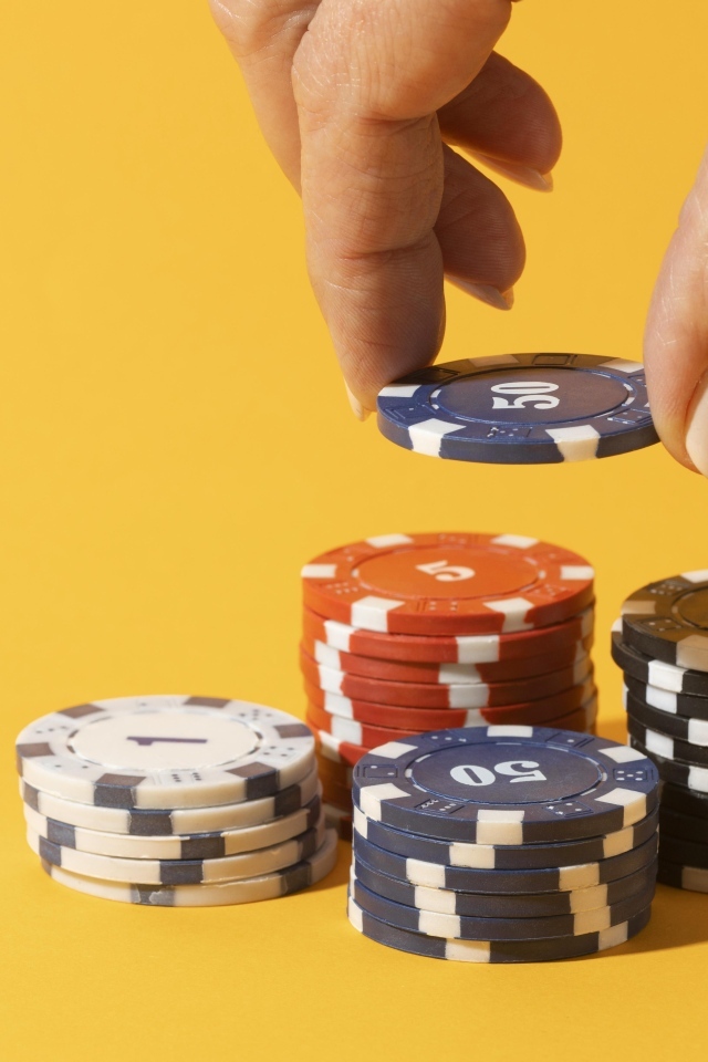 Фишки для казино с рукой на желтом фоне
