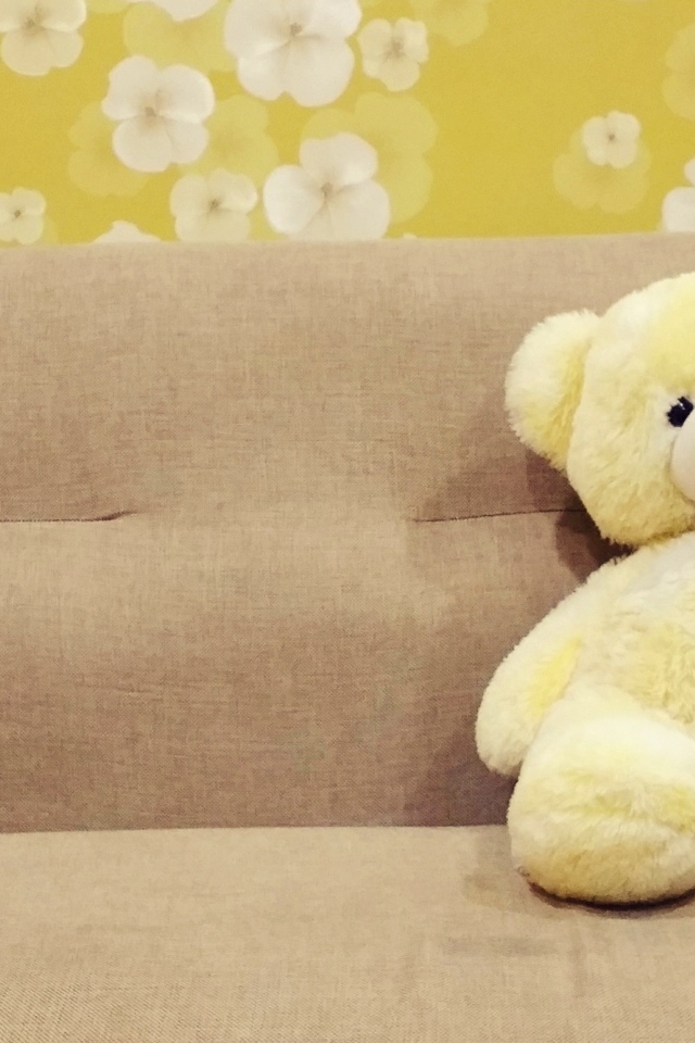 Милый игрушечный медведь на диване