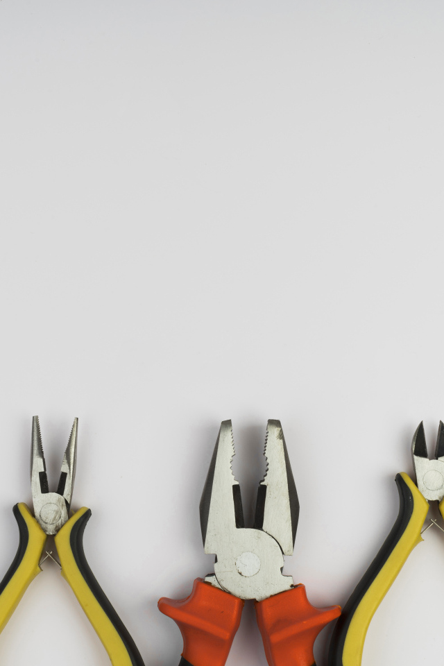 Разные плоскогубцы на сером фоне