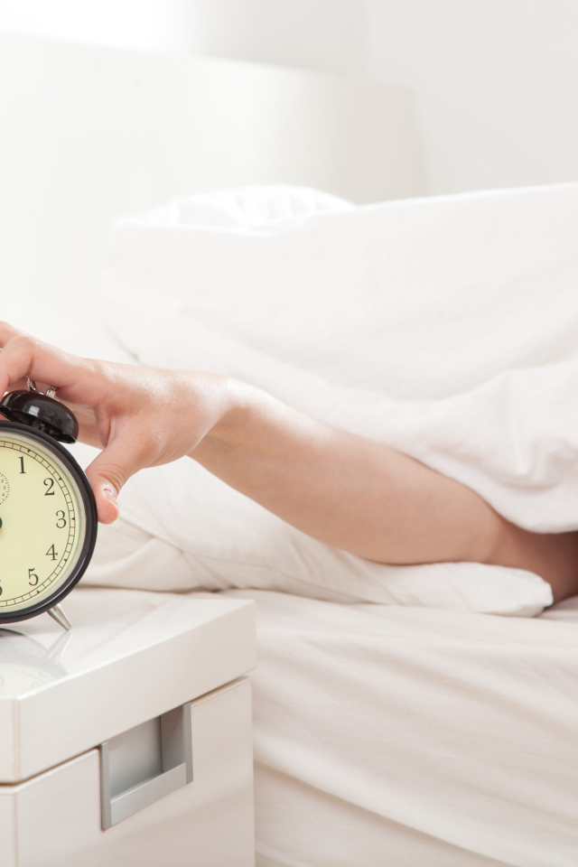 Рука под одеялом отключает будильник