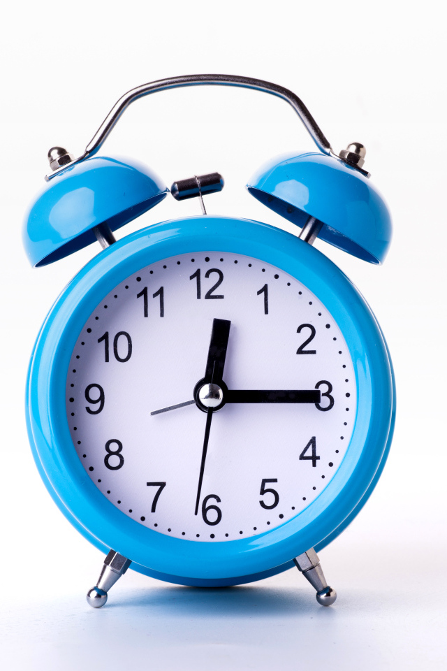 Большой голубой будильник на белом фоне