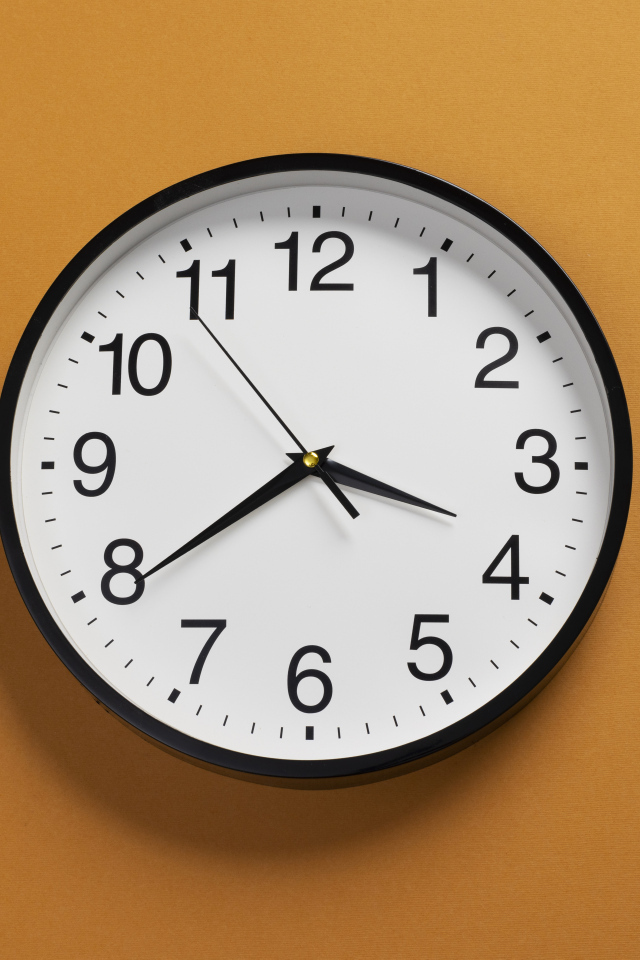 Большие круглые часы на желтом фоне