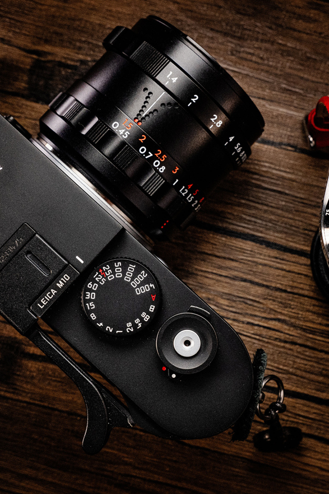 Фотоаппарат Leica M10 и часы на столе