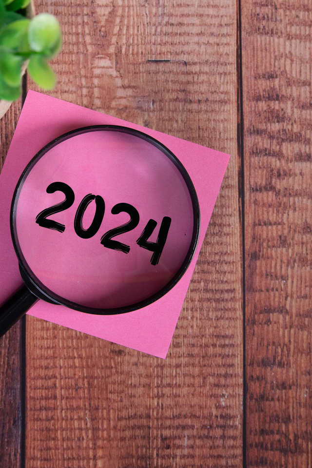 Увеличительное стекло с листом бумаги и цветком на столе