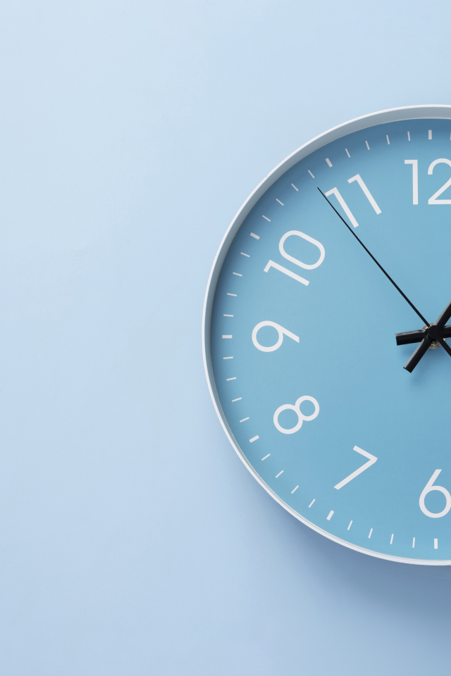 Круглые часы на голубом фоне крупным планом