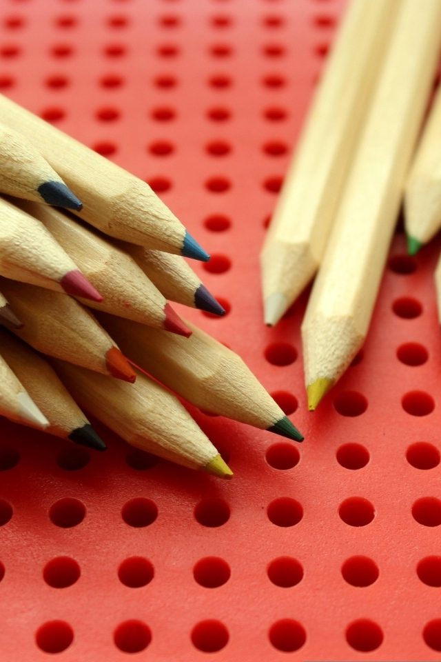 Заточенные карандаши на красном фоне