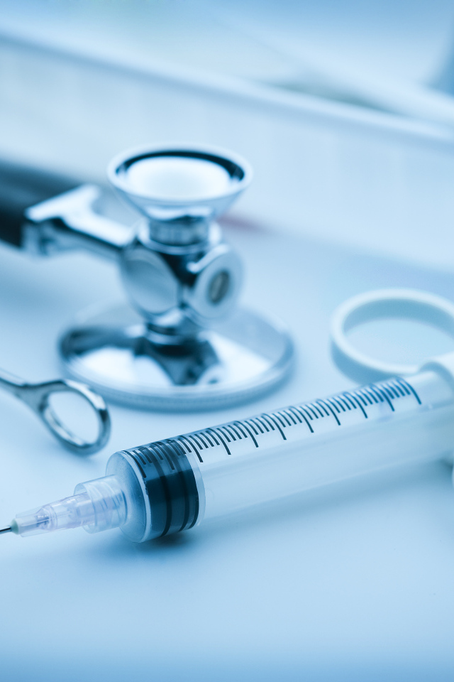 Шприц, зажим  и стетоскоп на столе