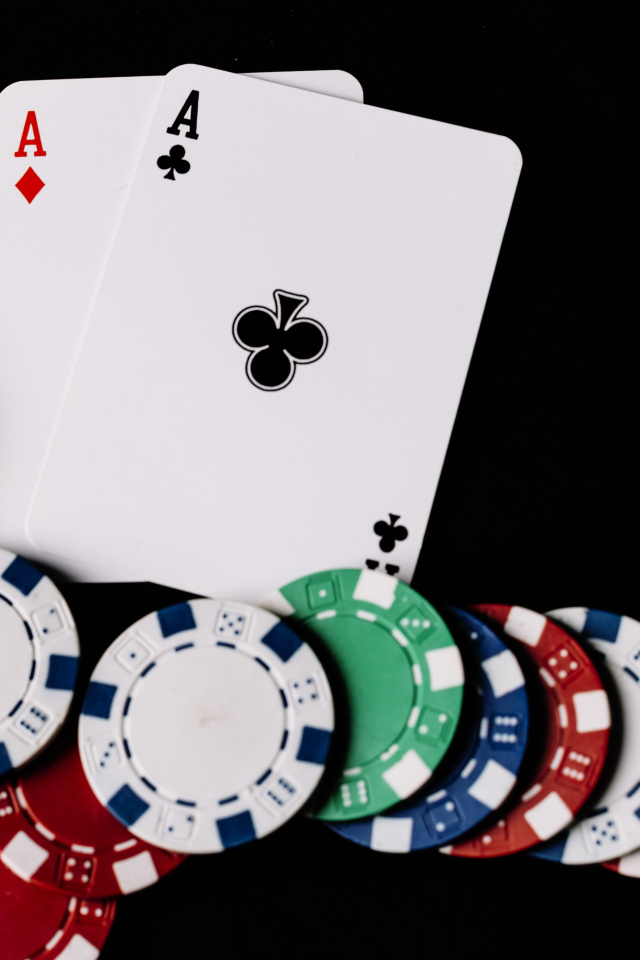 Два туза и фишки для покера  на черном фоне