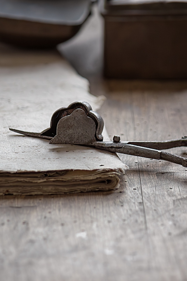 Старинные железные ножницы с бумагой на столе