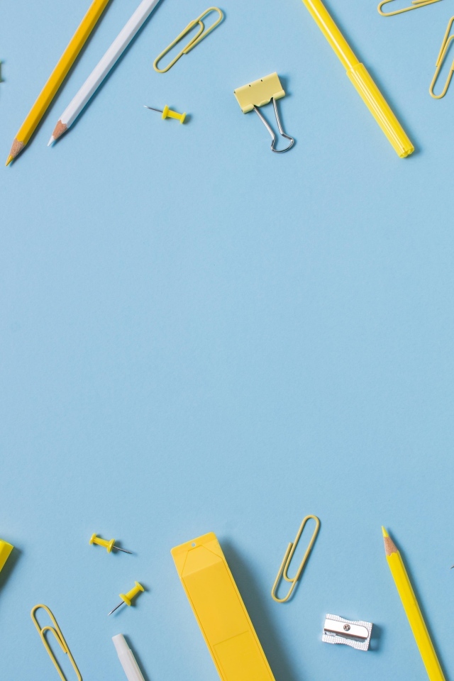 Желтые канцелярские предметы на голубом столе