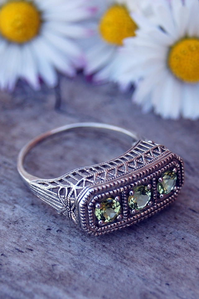 Старинный перстень на столе с ромашками