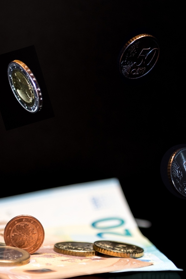 Купюры с монетами на черном фоне