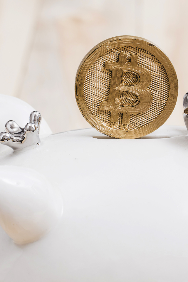 Золотая монета биткоин с копилкой