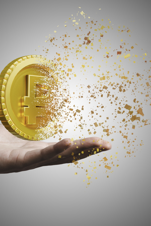 Монета разрушается на ладони на сером фоне