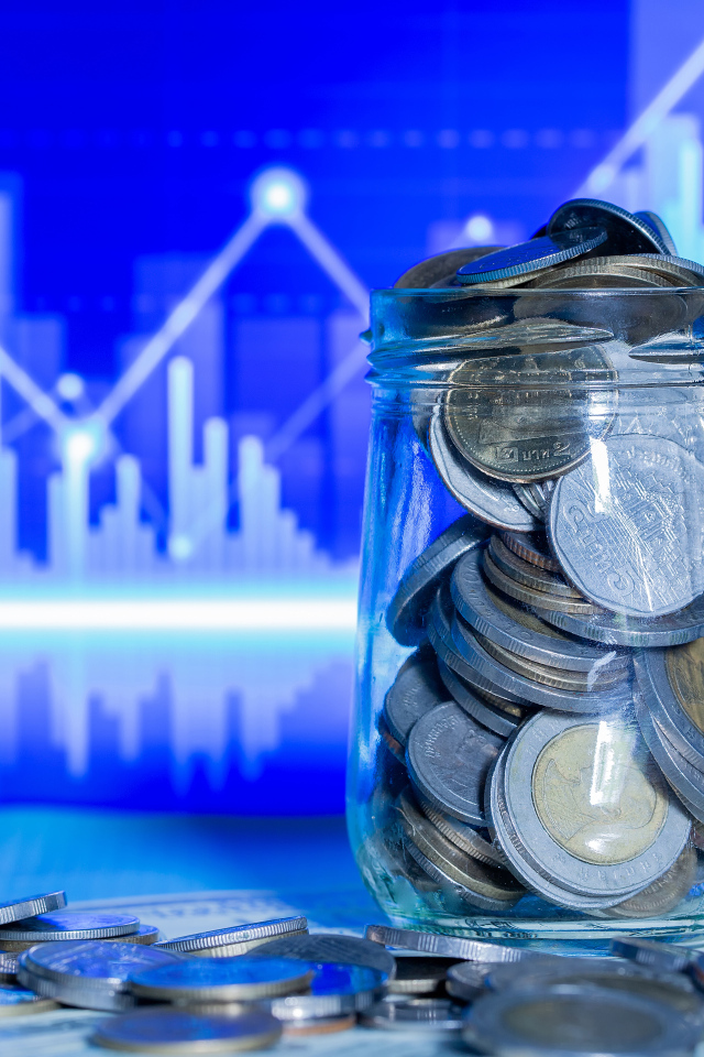 Банка с монетами на фоне таблицы