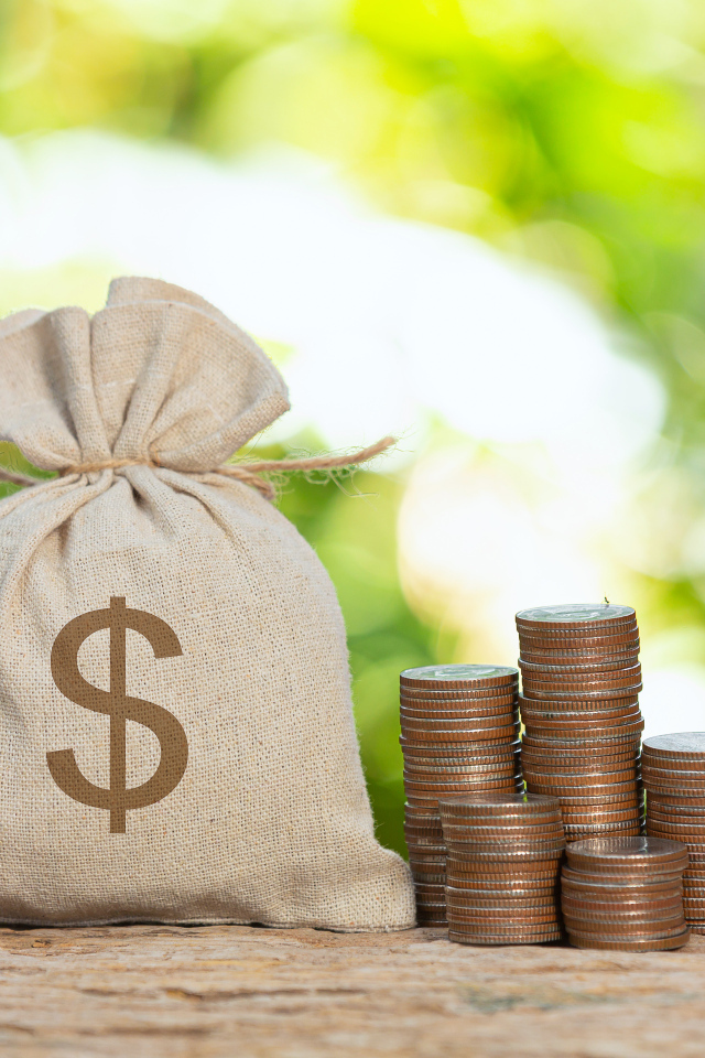 Мешок с деньгами на столе с монетами