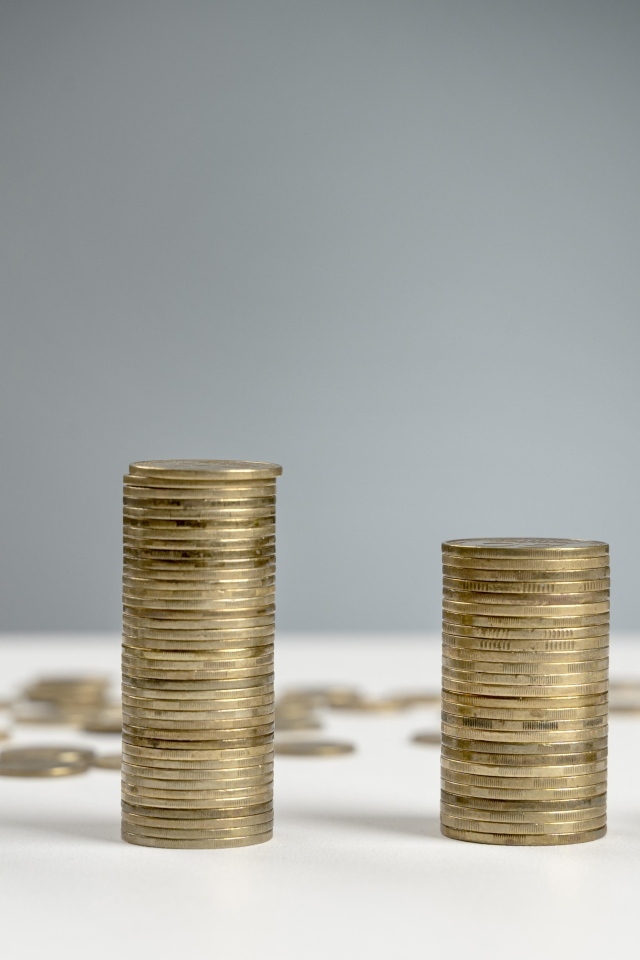 Стопки монет на сером фоне на столе