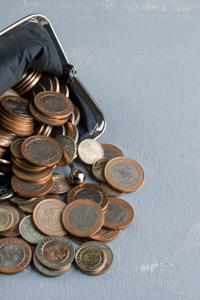 Кошелек с монетами на сером столе