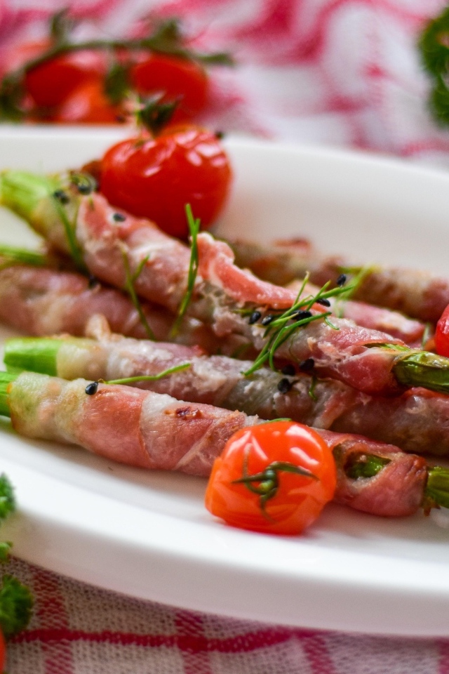 Спаржа в беконе на тарелке с вареными яйцами